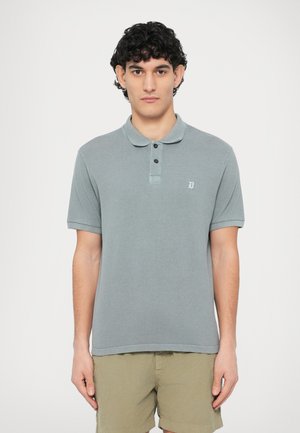 Gray cotton polo shirt with a collared neck, three black buttons, short sleeves, and a small logo on the left chest. Paired with beige shorts.
