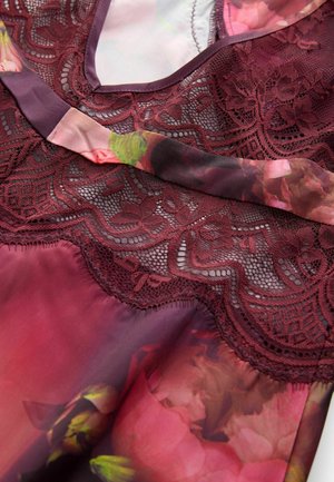 Bordeaux bloemenkant top met een doorzichtige stoffen overlay, met een delicate bloemenpatroon en textuurkant details.