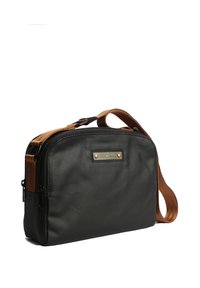 Cartella a messenger in pelle nera con una superficie texturizzata, tracolla in pelle marrone e un accento in hardware di ottone sul davanti. Chiusura con cerniera.