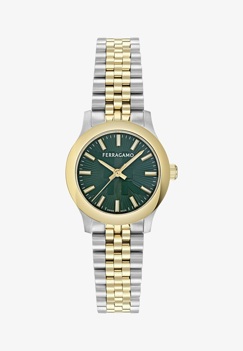 Arany és ezüst színű fém óra zöld mintás számlappal. Merész órák jelölői, vékony mutatók és két színű karkötő jellemzi.