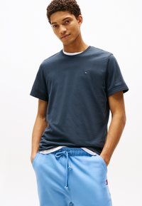 Mörkblå bomullst-shirt med korta ärmar och rund hals, med en liten logga broderad på bröstet.