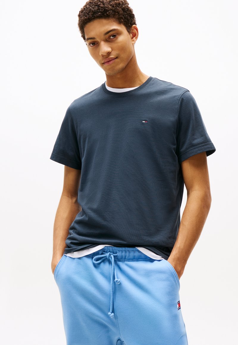 Mörkblå bomullst-shirt med korta ärmar och rund hals, med en liten logga broderad på bröstet.