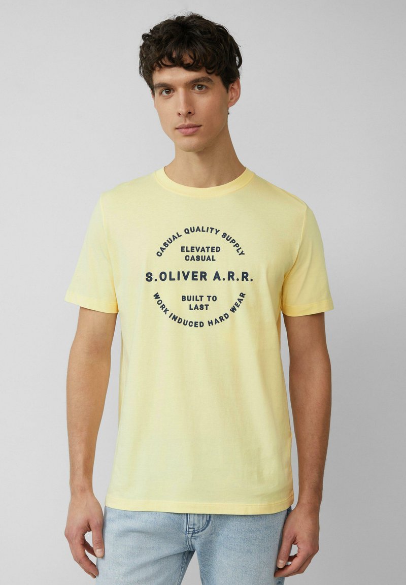 Geel T-shirt met korte mouwen, gemaakt van zachte katoen. Bevat een ronde grafische print in marineblauw met de tekst: "CASUAL QUALITY SUPPLY" en "BUILT TO LAST."