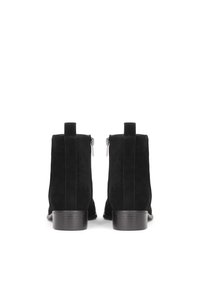 Botines de ante negros con un acabado suave, que cuentan con cremalleras laterales, un tacón bajo apilado y un diseño simple y elegante.