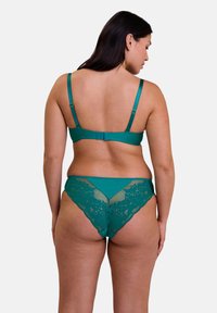 Ensemble de lingerie vert émeraude comprenant un soutien-gorge doux avec des bretelles réglables et un slip à dos en dentelle assorti, orné d'un motif floral et de bords festonnés.