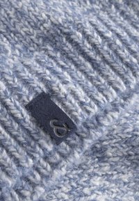 Gestrickte Beanie in Hellblaumit elfenbeinfarbenen Strängen. Verfügt über ein dunkelblaues Stoffetikett mit einem grauen Logo. Strukturmaterial aus weichem Wollmix.