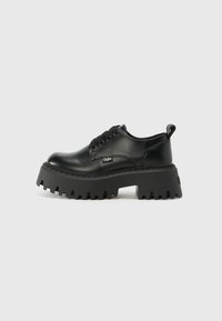 Black platform shoes made of smooth leather with a chunky, textured sole and rounded toe. Features six eyelets and a pull tab.