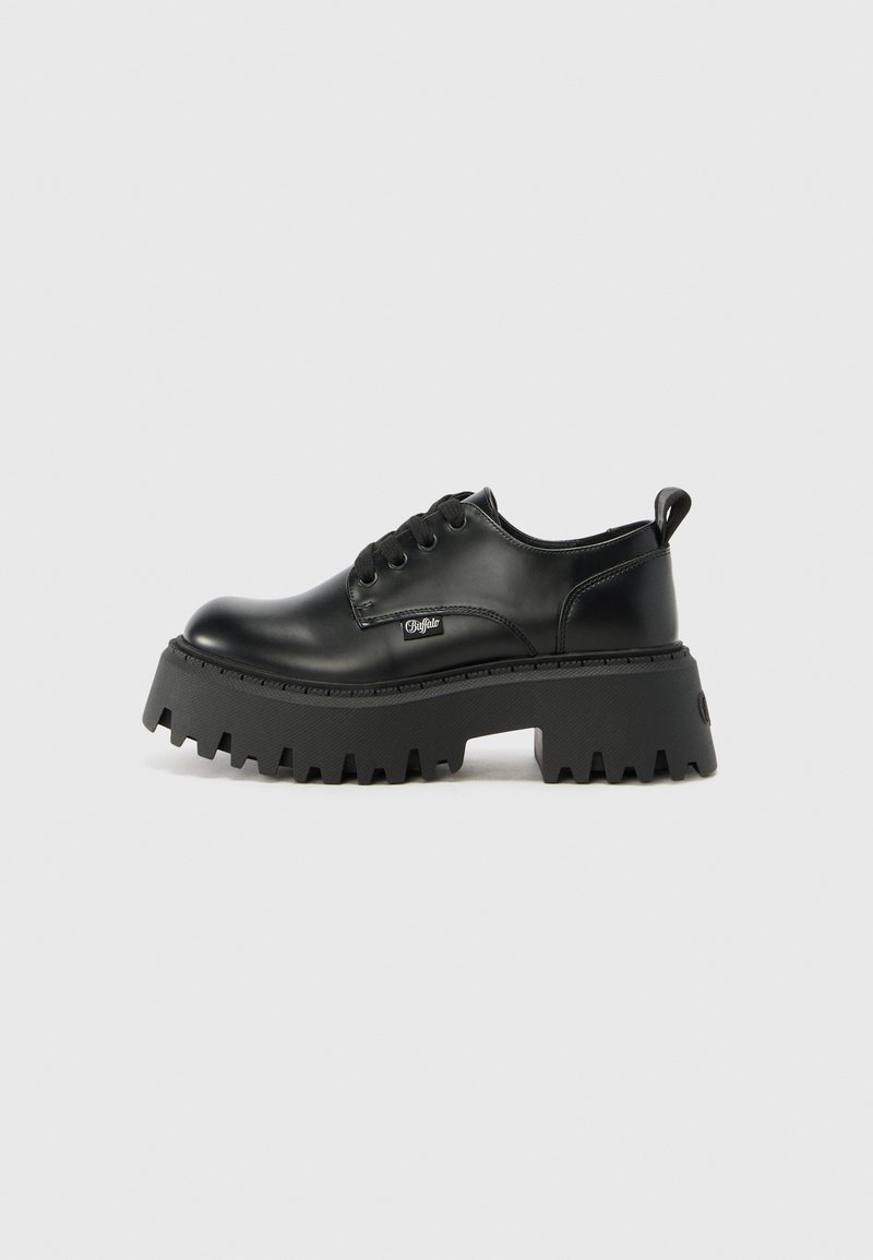 Black platform shoes made of smooth leather with a chunky, textured sole and rounded toe. Features six eyelets and a pull tab.