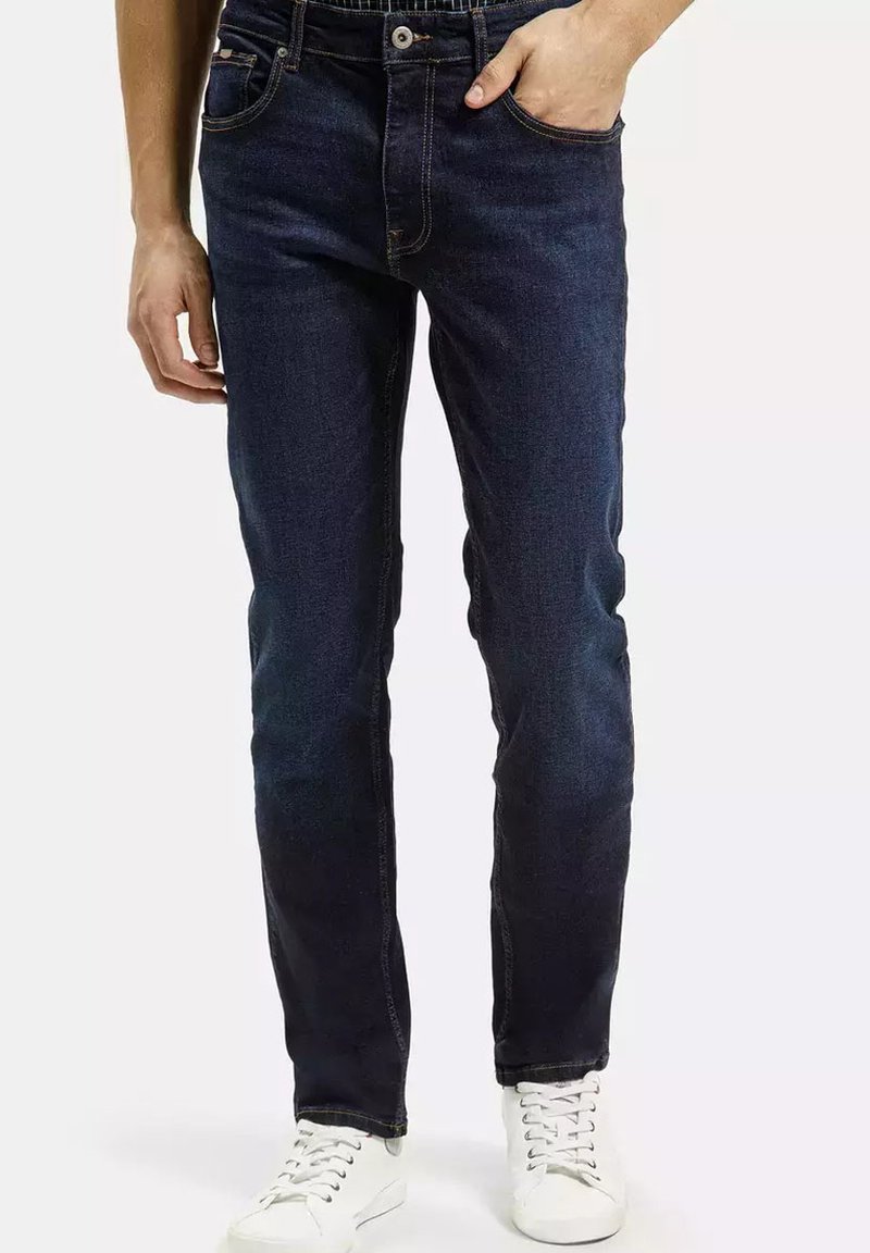Granatowe dżinsy o prostym kroju, pięciu kieszeniach i kontrastowych szwach, z wygodnym wyglądem i gładką fakturą.