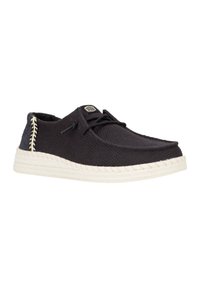 Le scarpe in tessuto nere presentano una texture intrecciata, una suola bianca intrecciata e dettagli di cucitura a contrasto sui lati. I lacci anteriori assicurano una vestibilità sicura.