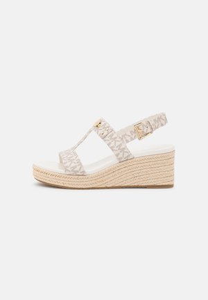 Beige kilehæle sandal med vævet jute sål, stropper i stof med et diskret logomønster, og guldfarvede hardwaredetaljer. Justerbar ankelsnor.