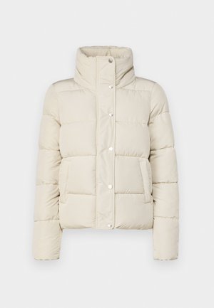 Puhasta jakna v krem barvi, z visokim ovratnikom, pritiskači in dvema sprednjima žepoma. Narejena iz mehke, quited tkanine. Lahka zasnova.