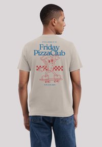 Lichtgrijze T-shirt met een cartoon pizza personage op een skateboard, met blauwe en rode tekst, en een geblokt patroon eronder.