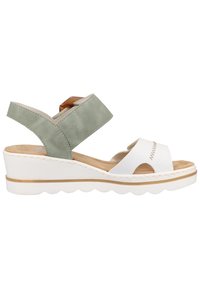 Sandale compensée avec une bride en cuir blanc au niveau des orteils et une bride de cheville en daim vert. Comprend une semelle intérieure texturée et une semelle extérieure blanche rayée.