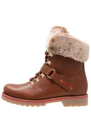 Bottine en cuir brun avec un poignet en fausse fourrure, quincaillerie dorée et accent rouge sur la semelle. Présente un design à lacets et un détail de sangle sur le côté.