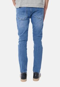 Jeans in denim blu con una vestibilità dritta, dotati di tasche posteriori, una leggera sfumatura e un dettaglio di cucitura a contrasto in vita.