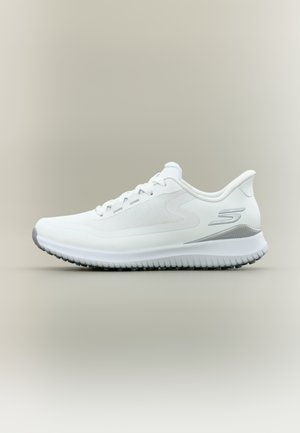 Zapatilla deportiva blanca con parte superior texturizada, punta redondeada y un acento gris en la suela. Cuenta con un diseño de cordones y un talón que brinda apoyo.