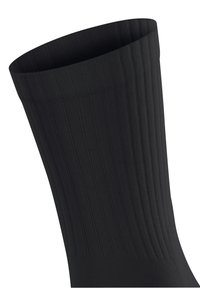 Czarna, prążkowana skarpeta o miękkiej fakturze, z mankietem na górze. Projekt zawiera pionowe linie dla dodatkowego detalu.