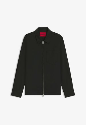 Veste noire avec fermeture éclair à l'avant, col pointu, manches longues et poche poitrine. Fabriquée en tissu lisse avec des détails de design minimalistes.