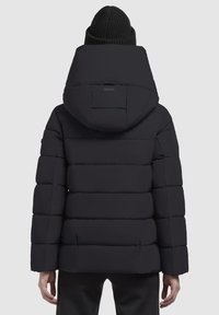 Schwarze Steppjacke mit Kapuze, mit einem gesteppten Design und einem rechteckigen Etikett auf der Rückseite. Das Material scheint glatt und isoliert zu sein.