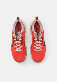 Røde trail-løbesko med åndbart mesh-overmateriale, grå accenter, hvide snørebånd, spraglet mellemsål og et sort logo på siden.