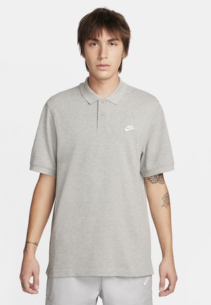 Lys grå polo skjorte laget av myk stoff, med en brettet krage, korte ermer, tre knapper, og en liten hvit Nike-logo på brystet.