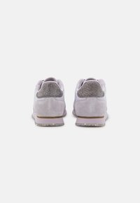 Ljuslila träningsskor med en texturerad grå bakdel, i mockamaterial, vadderad krage och genomskinlig gummisula.