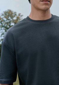Donkergrijze t-shirt van zacht katoen, met een ronde hals en korte mouwen, subtiele stiksels en een comfortabele pasvorm.