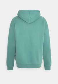 Felpa con cappuccio in turchese, con una vestibilità comoda, tessuto morbido, polsini e fondo a coste. Presenta un retro senza tasche e un tessuto liscio.
