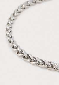 Colar de corrente de prata polida com elos retangulares espessos e interligados, exibido sobre um fundo branco simples.