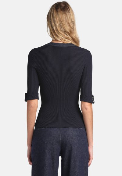 Marineblaues, geripptes Oberteil mit kurzen umgeschlagenen Ärmeln, figurbetontem Design und leicht ausgestelltem Saum. Weiche Textur, minimalistische Details und Rundhalsausschnitt.