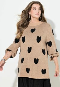 Maglione beige lavorato a maglia con motivi a cuore neri, scollatura rotonda e maniche a tre quarti. Tessuto morbido e vestibilità comoda.