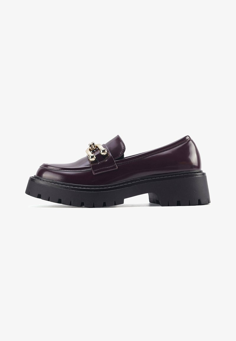 Läikivad burgundia värvi loaferid, millel on dekoratiivne kuldne metallketi detail, paks musta kummitald ja ümar varvas.