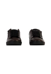 Sneaker in pelle marrone con lacci neri, suole in gomma nere e piatte, e dettagli con zip ai lati. Texture liscia e forma arrotondata.