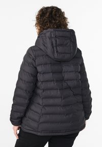 Mustast plõksviskoosist jope kapuutsiga, millel on tikkimisosad, keskmise pikkusega lõige ja elastsed mansetid. Sile tekstuur mati viimistlusega.