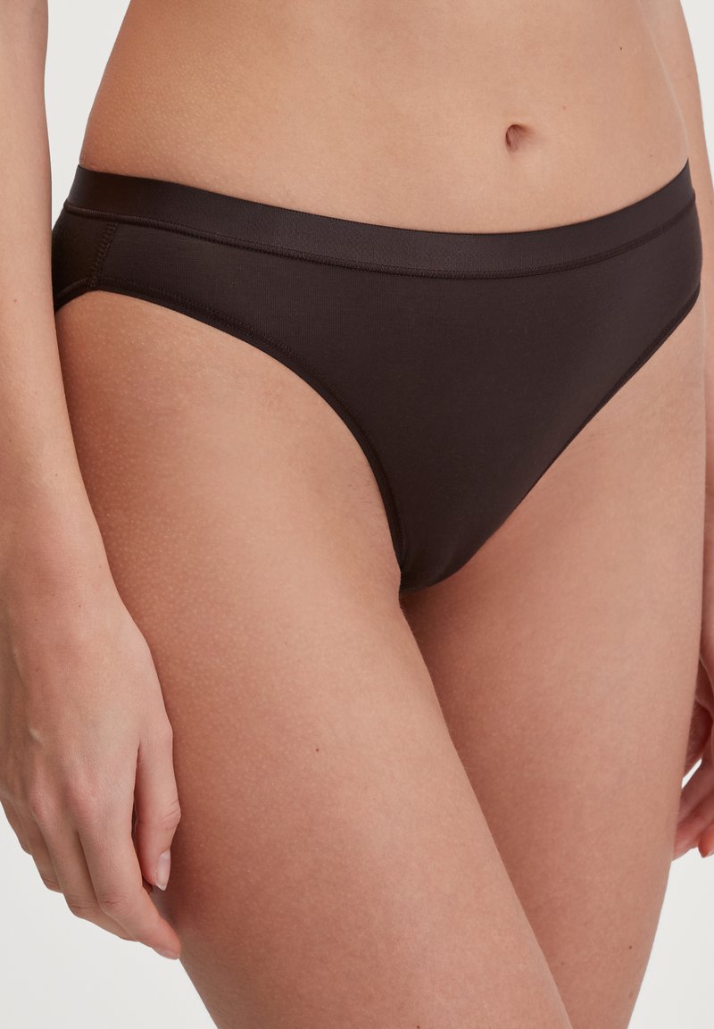 Biancheria intima bikini nera in cotone, con una texture liscia, design a vita bassa e cuciture minime. La copertura laterale è moderata.