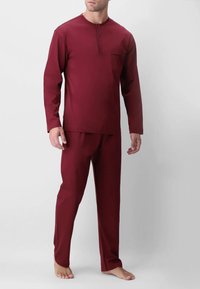 Set di abbigliamento loungewear bordeaux composto da una maglia a maniche lunghe con collo henley e bottoni e pantaloni coordinati. Tessuto morbido e leggero con un dettaglio tasca.