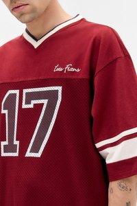 Maglia in rete rossa con accenti bianchi e blu navy. Presenta una scollatura a V e il numero "17" stampato in grigio. "Lets Frien" è ricamato sul petto.