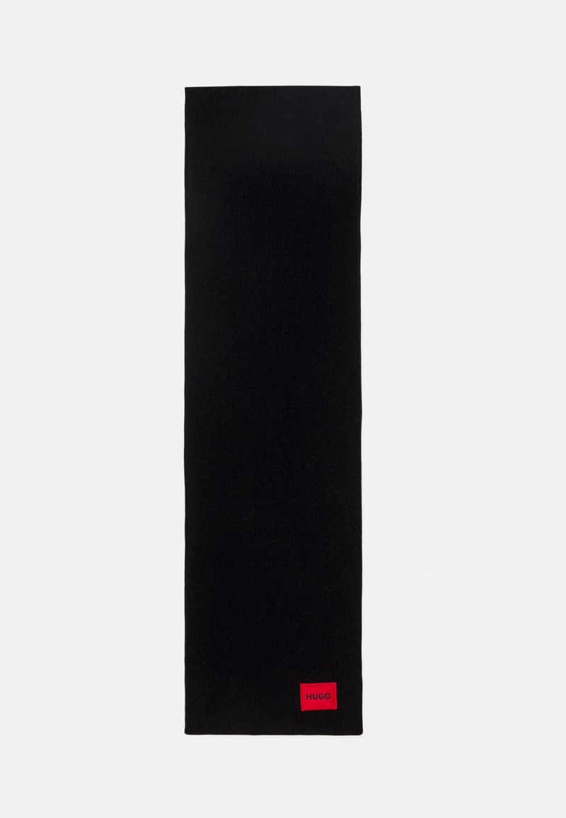 Sort strikket tørklæde, forlænget form, glat tekstur, med et lille rødt mærke med "HUGO" i den ene ende, minimalistisk design.