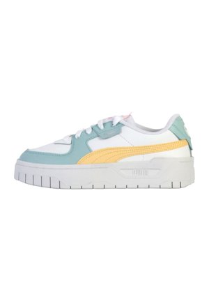 Zapatilla blanca con acentos en aqua y amarillo, con una parte superior texturizada, lengüeta acolchada y suela gruesa y acanalada. Detalle del logotipo visible en el lateral.