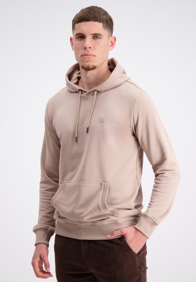 Bež hoodie s kengursko žepom, vrvicama za zatezanje in rebrastimi manšetami. Ima majhen logo na prsih. Gladka tekstura, sproščen način oblikovanja.