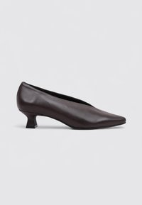 Zapato de vestir de cuero marrón con punta afilada, tacón bajo y textura suave. El diseño presenta una silueta elegante y minimalista.
