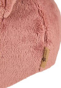 Close-up of a soft, pink plush fabric with a brown sewn-in label reading "Sterntaler" on the side.