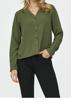 Chemise olive verte à col en V, à manches longues et à coupe décontractée. Comprend des boutons sur le devant et un ourlet légèrement arrondi.