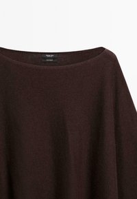 Maglione in cashmere marrone scuro con un ampio scollo rotondo, appeso su uno sfondo bianco.