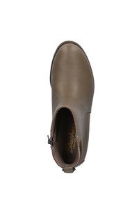 Bruine leren enkelboot met een gladde afwerking, zijritssluiting en gevoerde binnenzool. Kenmerkt zich door minimale stiksels en een afgeronde teenvorm.