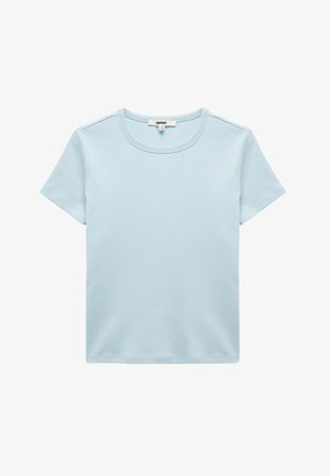 Camiseta de algodón de color azul claro con cuello redondo, mangas cortas y una textura suave; cuenta con costuras a lo largo de los hombros.