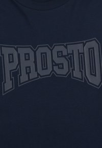 Granatowa koszulka z bawełny, z napisem "PROSTO" wydrukowanym na piersi w boldowanym, jasnoszarym, łukowatym kroju.