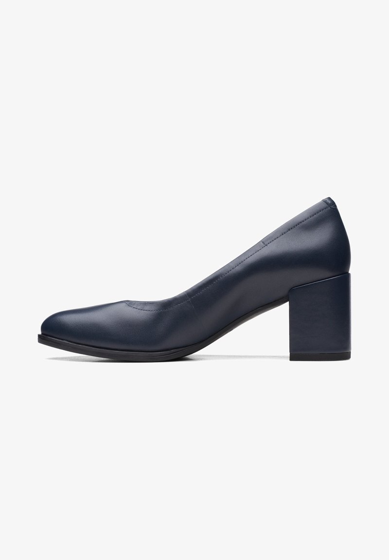 Escarpin pour femmes en cuir bleu marine avec un bout arrondi et un talon épais, bas et carré, présenté de profil sur un fond blanc.
