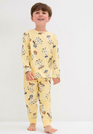 Set di pigiama giallo con motivi di animali giocosi, tra cui scimmie. Il tessuto è morbido, con maniche lunghe e pantaloni con polsini elastici.